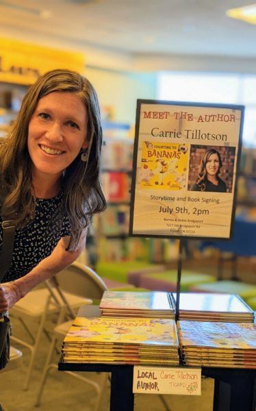 Author Carrie Tillotson posing with books and sign at Barnes and Noble.