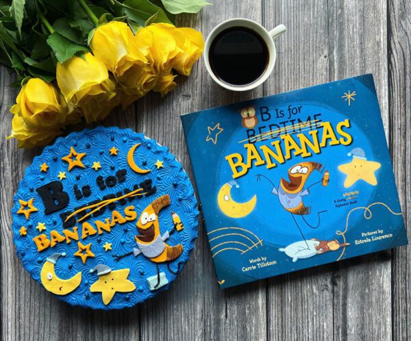 The book B IS FOR BANANAS, with a pie decorated like the cover, yellow roses, and a cup of coffee.